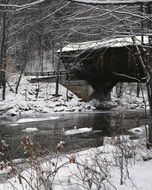 covered bridge over the creek in winter