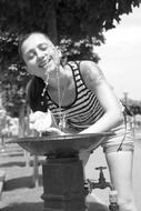 girl drinks water in the heat, black and white