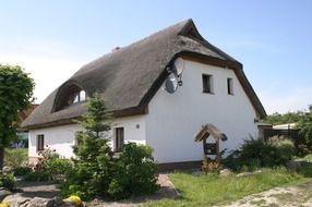 Nice white house with thatched roof in the countryside
