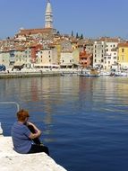 Woman looks at the Adriatic village harbor