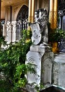 statue of a lion near the building with green plants