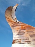 curved sculpture against a blue sky