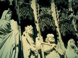 stone figures of men near the facade of the building