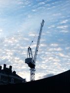 construction crane against the blue sky with clouds