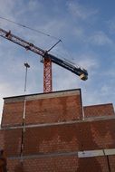 construction of a brick house on the background of a crane