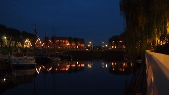 town on coast of north sea at night, germany, east frisia, caroline harbour