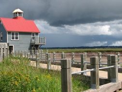 wooden house with a pink roof on the coast