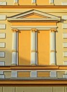 facade of a yellow house with white columns