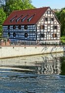 building with timber framing on waterfront, poland, bydgoszcz