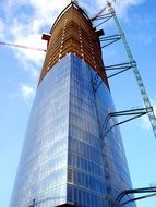 facing the glass facade of a skyscraper