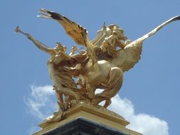 golden statue on a building in Paris