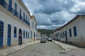 Cars among an old street in the background of a cloudy sky