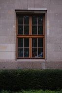 lattice window with wooden frame in stone wall