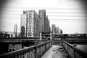 black and white photo of a city foot bridge