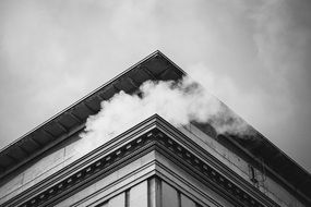 black and white photo of a building roof with smoke