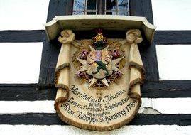 medieval coat of arms on facade of truss building close-up