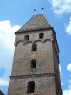 Old stone tower against the sky with clouds