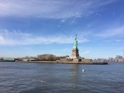 distant view of liberty statue and manhattan from water, usa, nyc