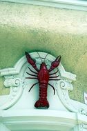 coat of arms of vu in the form of red crayfish on the facade of the building