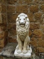 lion, aged marble sculpture at stone wall