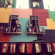 figures on balconies at colorful painted facade in caminito, street museum and a traditional alley, argentina, buenos aires