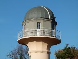 Alexander Franz Observatory among the trees at blue sky background