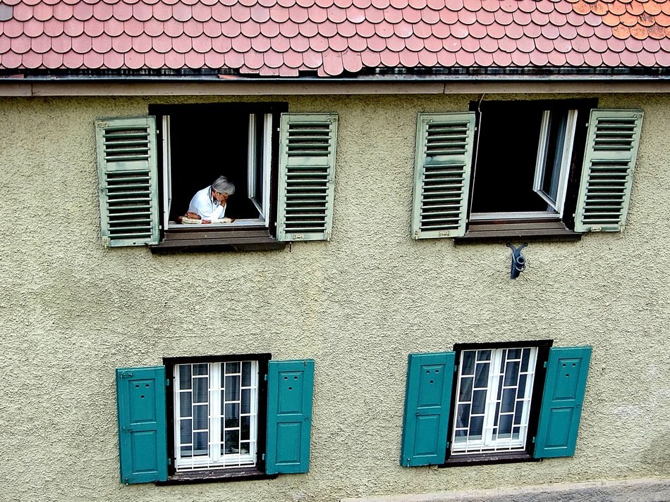person in the window with shutters