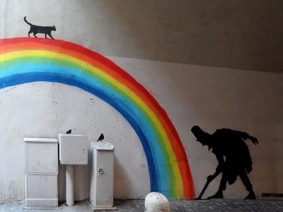 painted cat walking on a rainbow on the wall