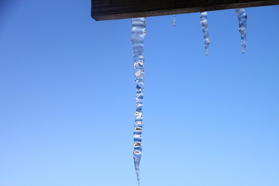 Icicles from the roof against a background of clear sky