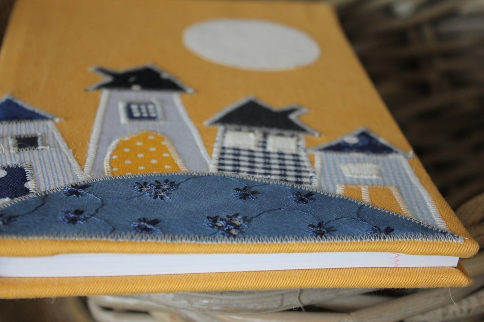 textile cover of book, houses on hill