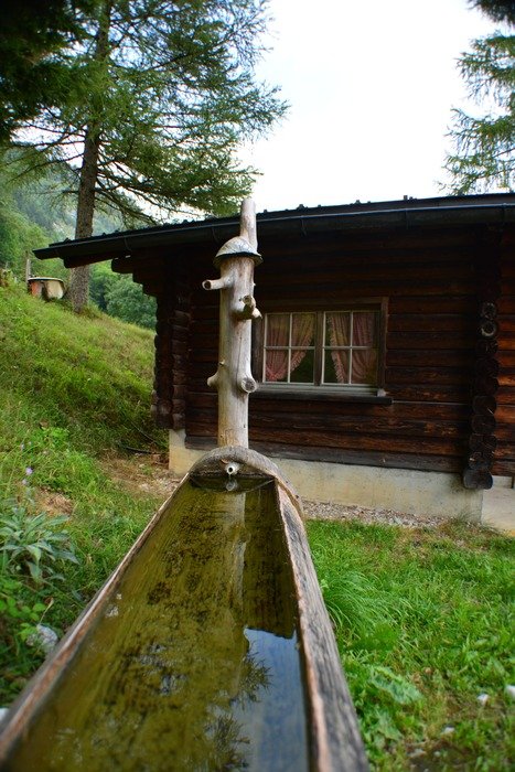 water fountain at wooden cabin, switzerland