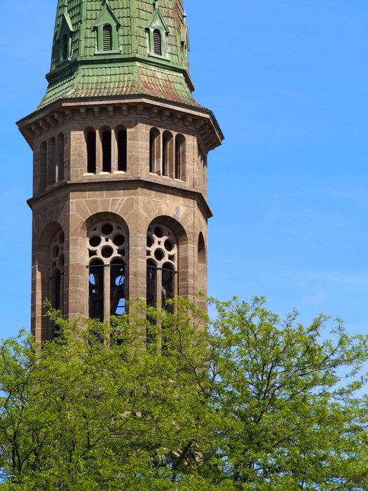 spire of an old tower against the blue sky