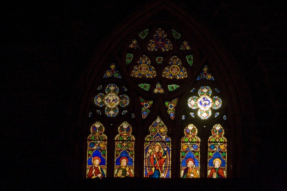Colorful stained glass church gothic window among the dark