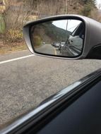 Rear-view mirror of the car among the plants