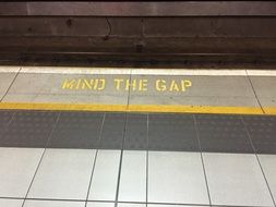 mind the gap, yellow lettering in underground, uk, england, london