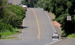 landscape of cars on hill road with speed limits signs