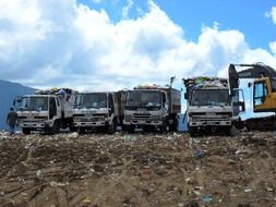 trucks with garbage at the dump