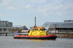 yellow tugboat in the harbor on a sunny day