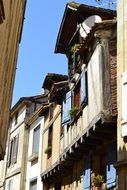 picture from below of old buildings on narrow street in france, bergerac