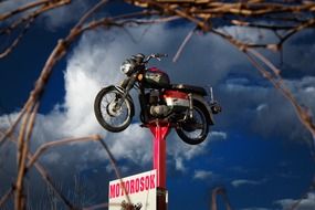 vintage motorbike on pillar at sky