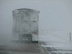 truck on the road in a snow storm