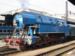 blue steam locomotive on the railroad