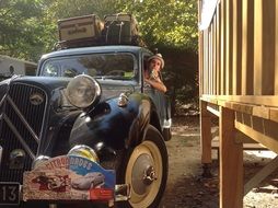 luggage is standing near an old car