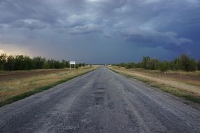 asphalt road under dark clouds