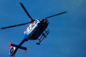 helicopter flies in the blue sky