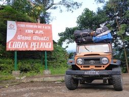 jeep stands near a traffic sign, indonesia