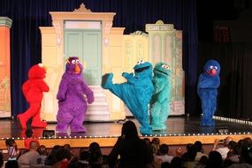 actors in colored costumes on stage