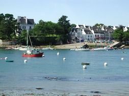 fishing boats in view of beautiful village on coast, france, brittany, sainte marine