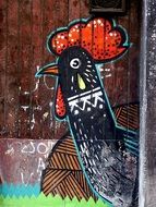 rooster graffiti on a wooden fence