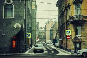 cars and traffic signs on old narrow street